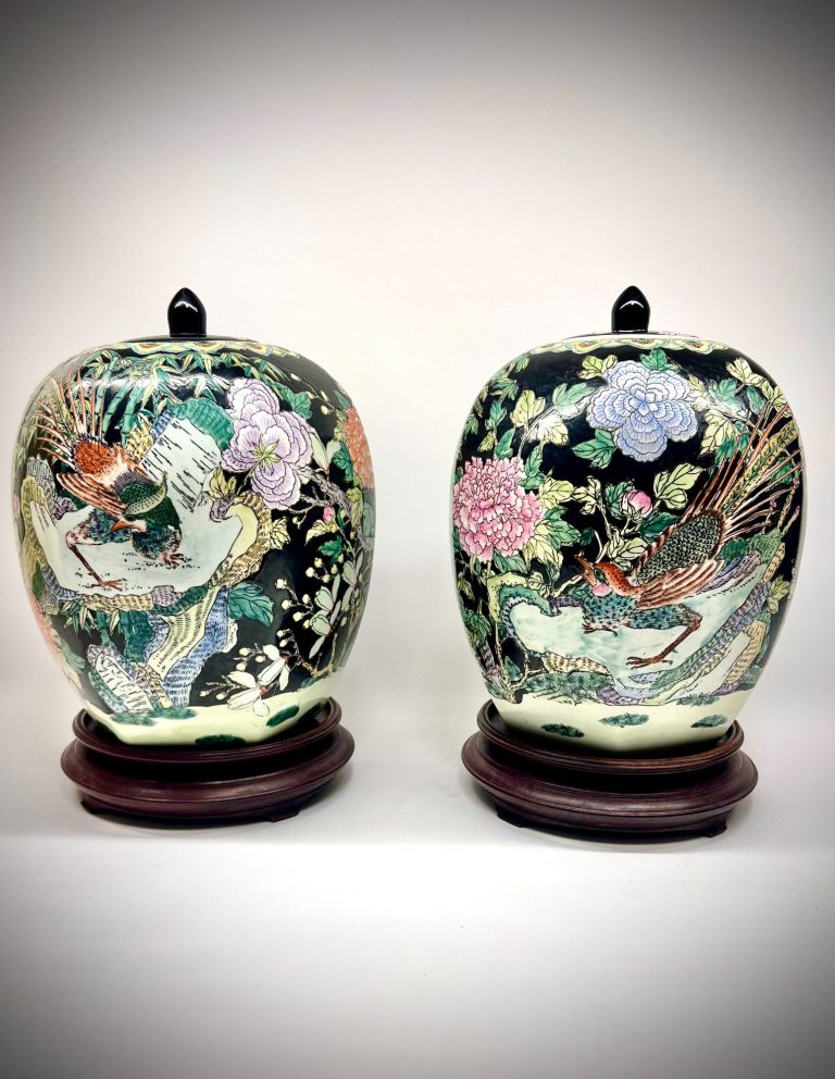 Pair of large Famille Noire Chinese ginger jars, hand-painted with pheasants and peonies. Includes lids and wooden stands.